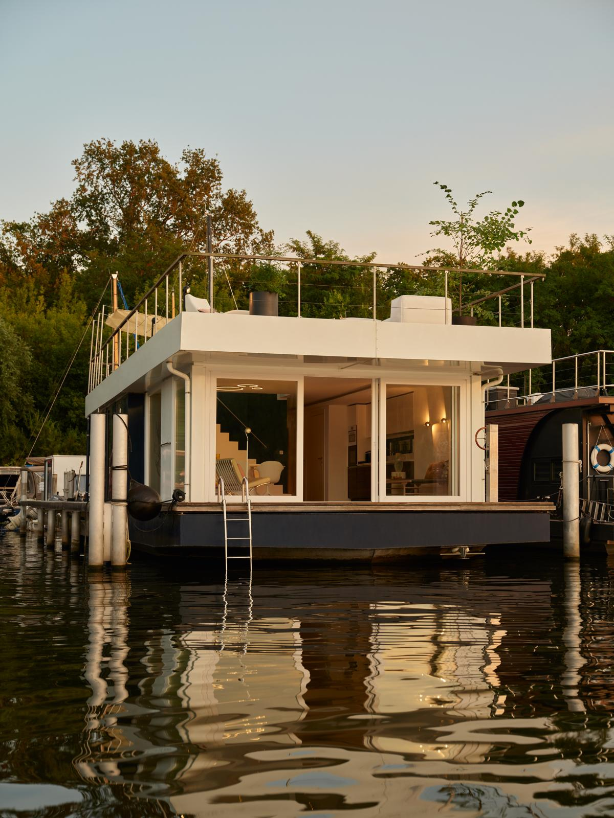 Interior lounge chair with floor-to-ceiling marina view at sunset